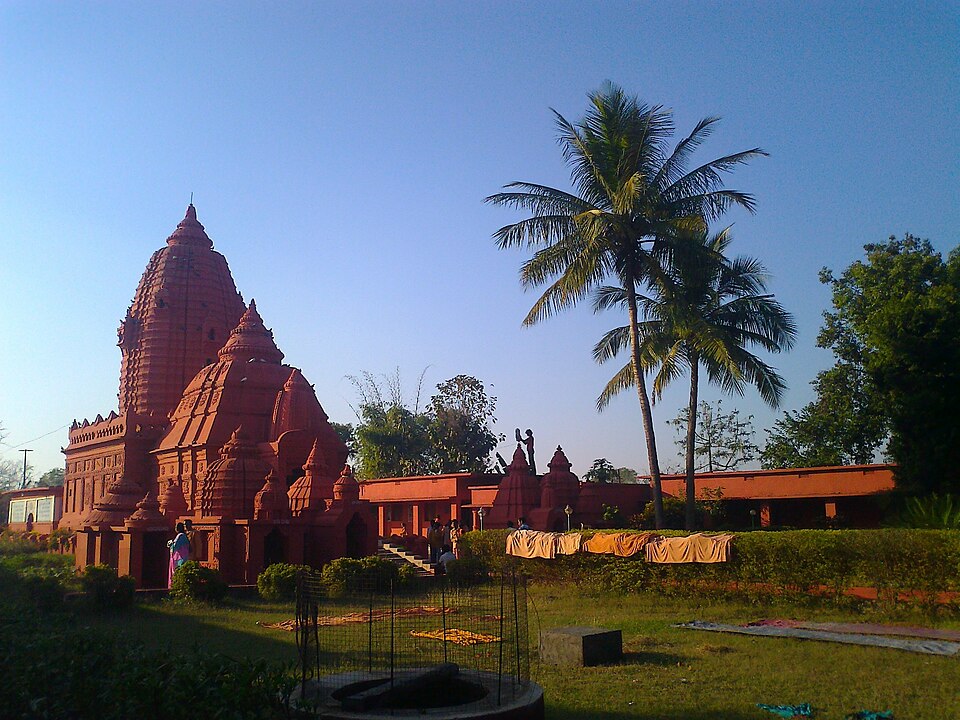 A red shrine and a palm tree at the Bhima Bhoi memorial in Khaliapali.