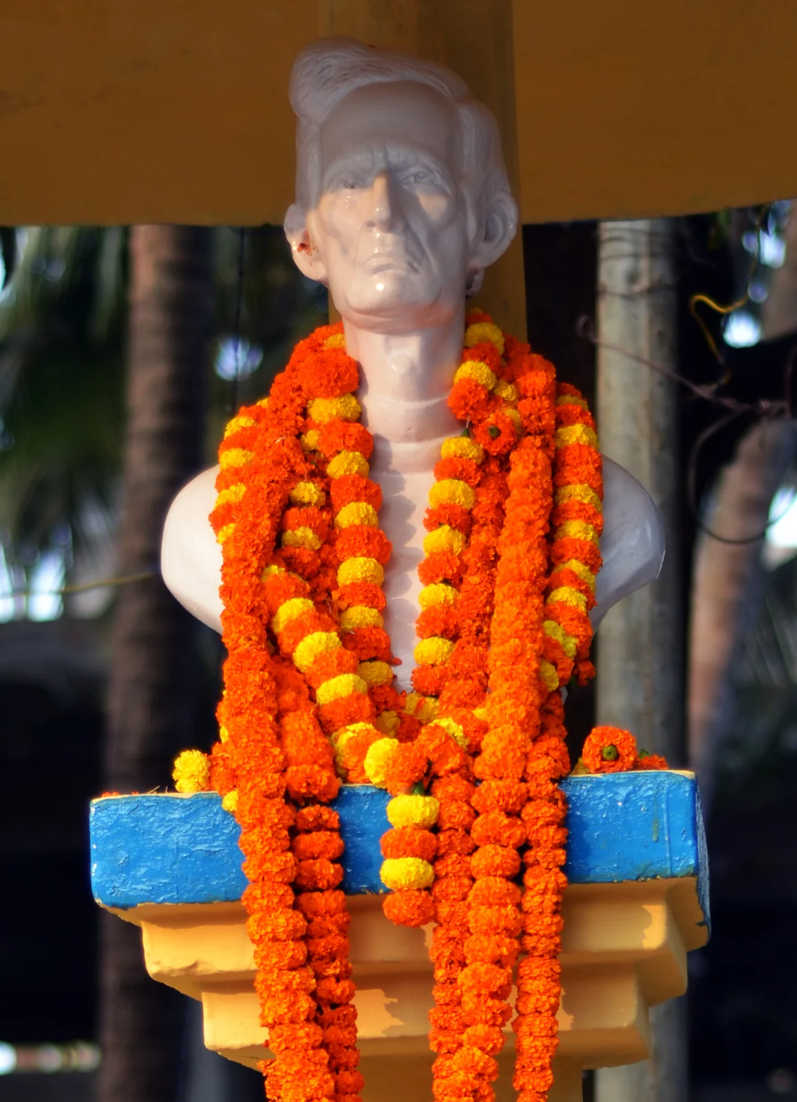 A garlanded commemorative bust of Fakir Mohan Senapati.