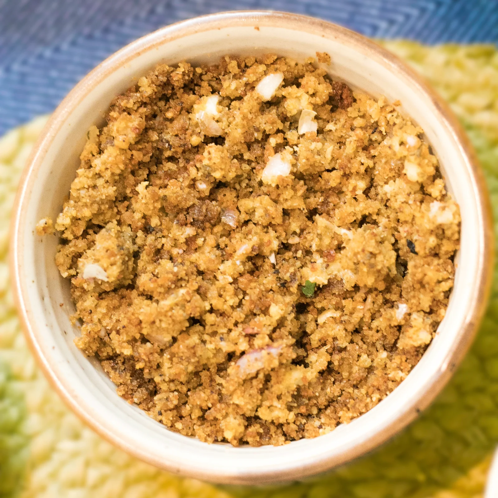 Coarsely crushed badi with pieces of onion in a small bowl.