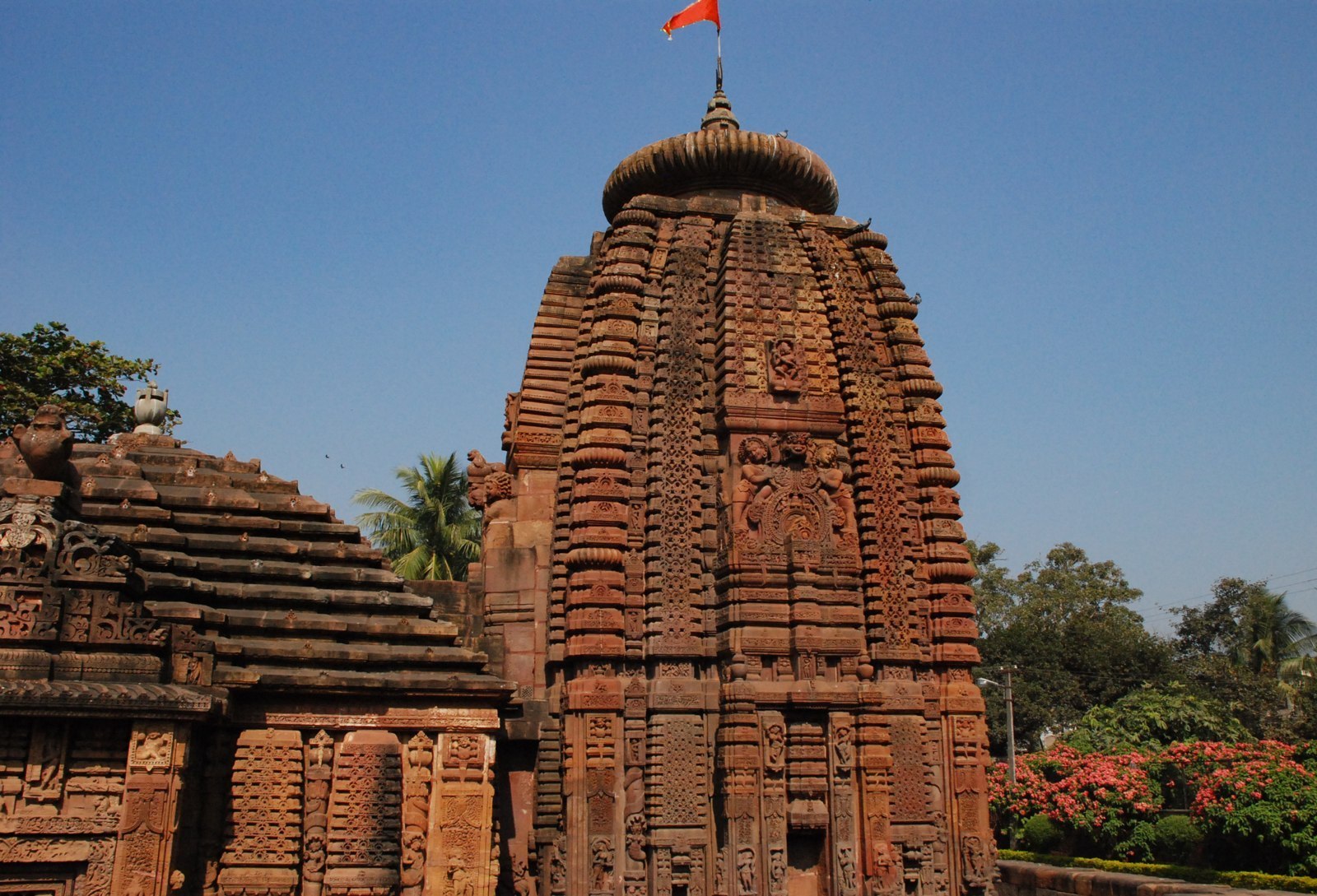 Carved stone temple towers at Mukteswar, Bhubaneswar, against a blue sky.