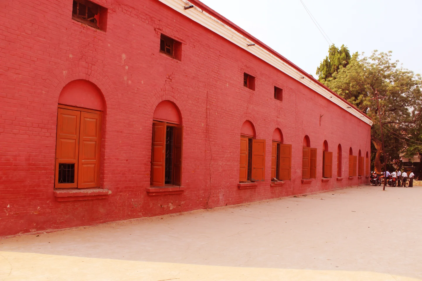Red brick building with a long row of shuttered windows at Ravenshaw Collegiate School.