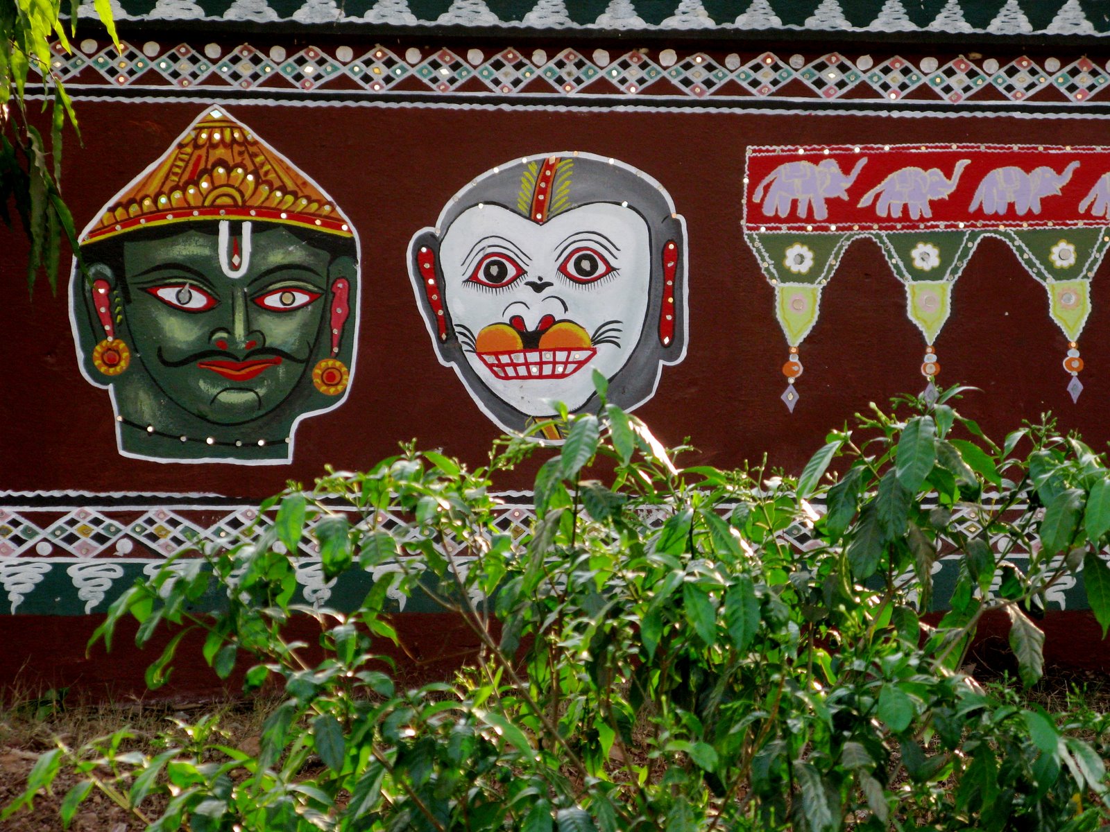 Painted masks behind roadside plants